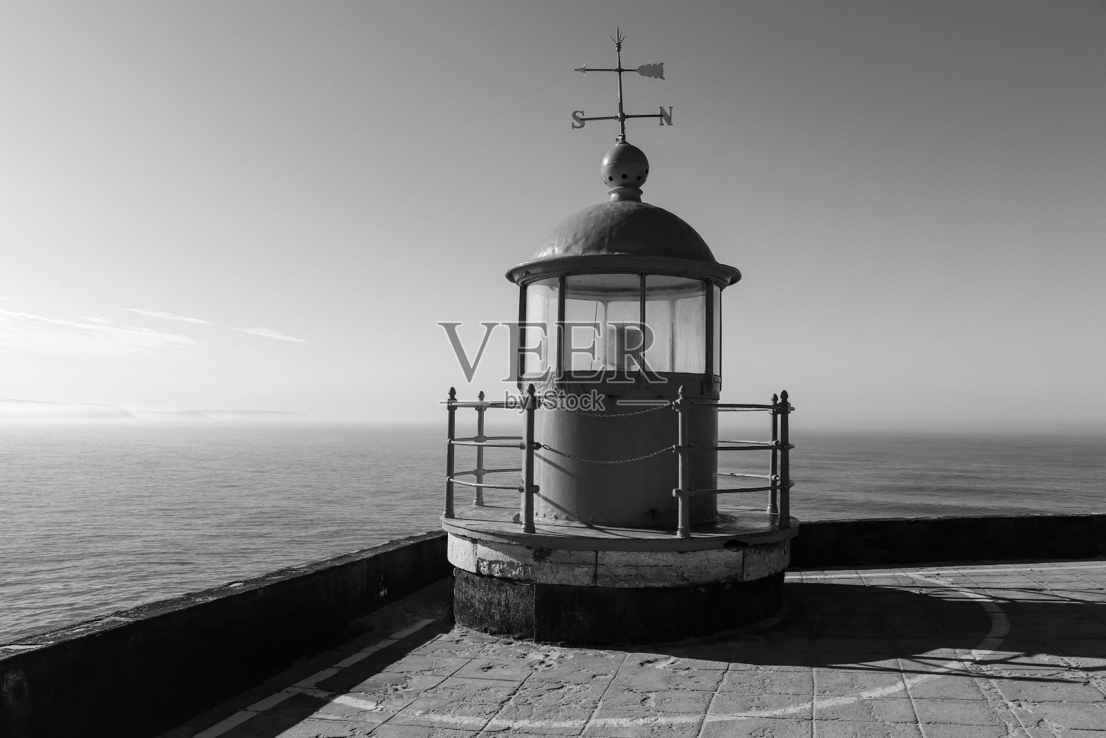 在葡萄牙的纳扎尔，蓝色的天空和大海背景上的红色灯塔灯房间照片摄影图片