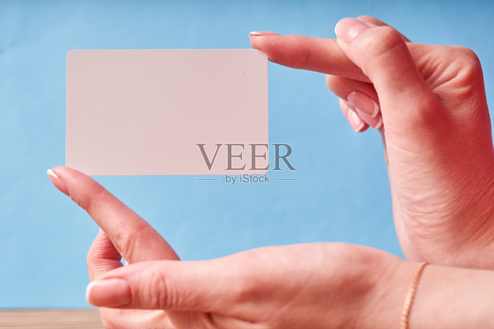 一个女人的手里拿着一张白色的塑料卡片。手持孤立卡片照片摄影图片