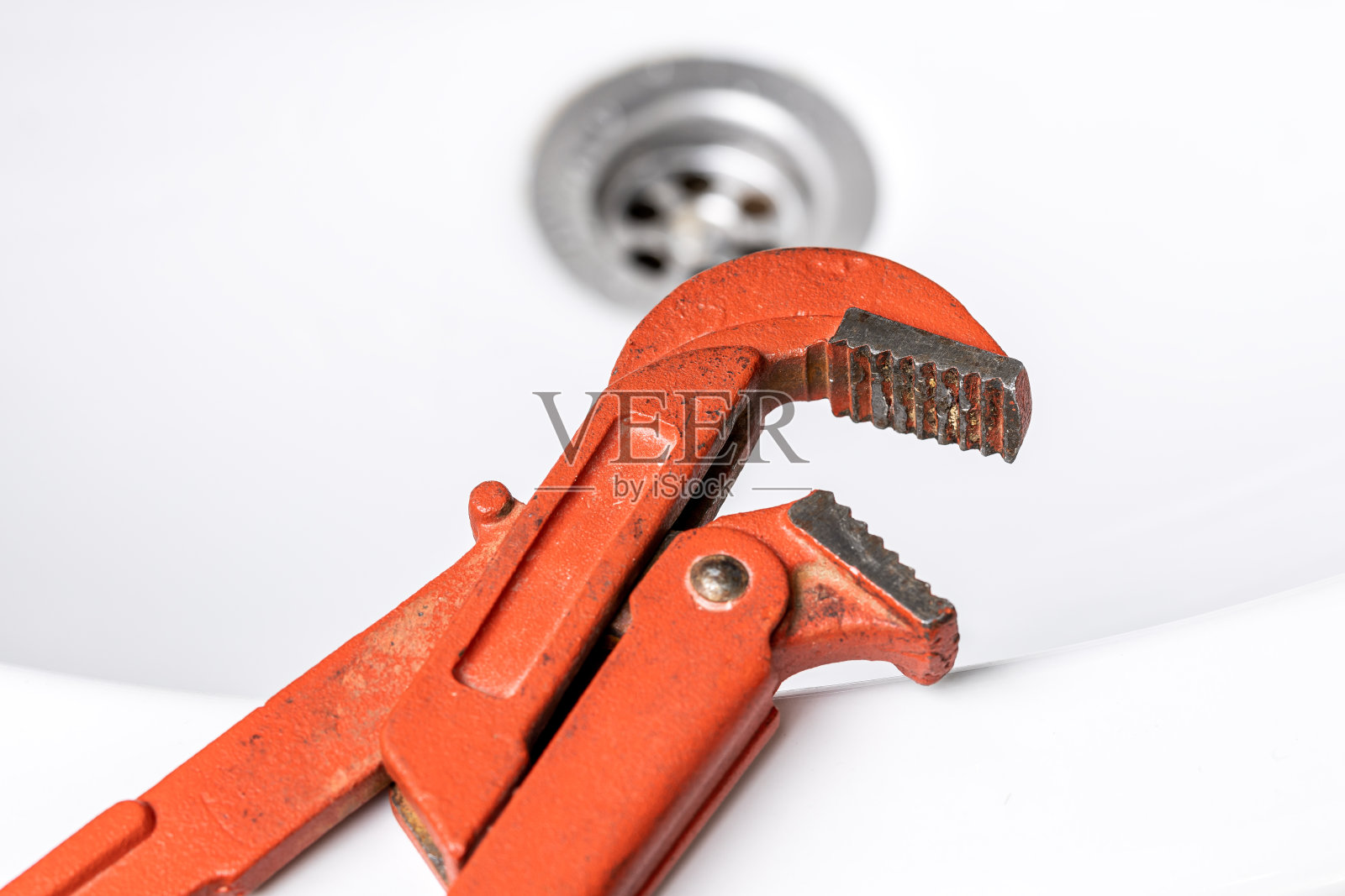 水管水龙头维修概念。水管工使用扳手工具和钳子来调节浴室的水龙头漏水。diy管道工概念照片摄影图片