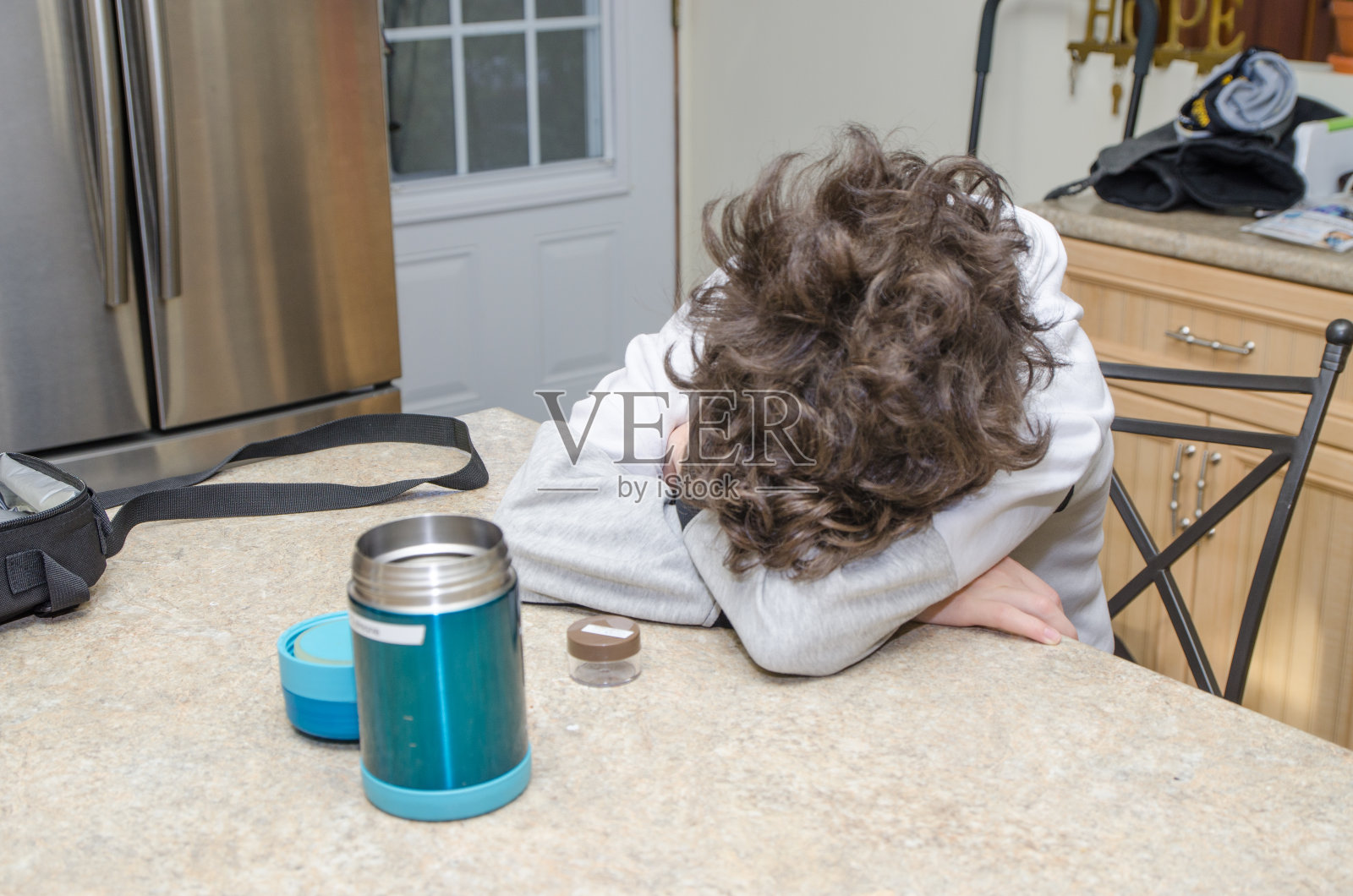 在厨房台面上睡觉的少年照片摄影图片