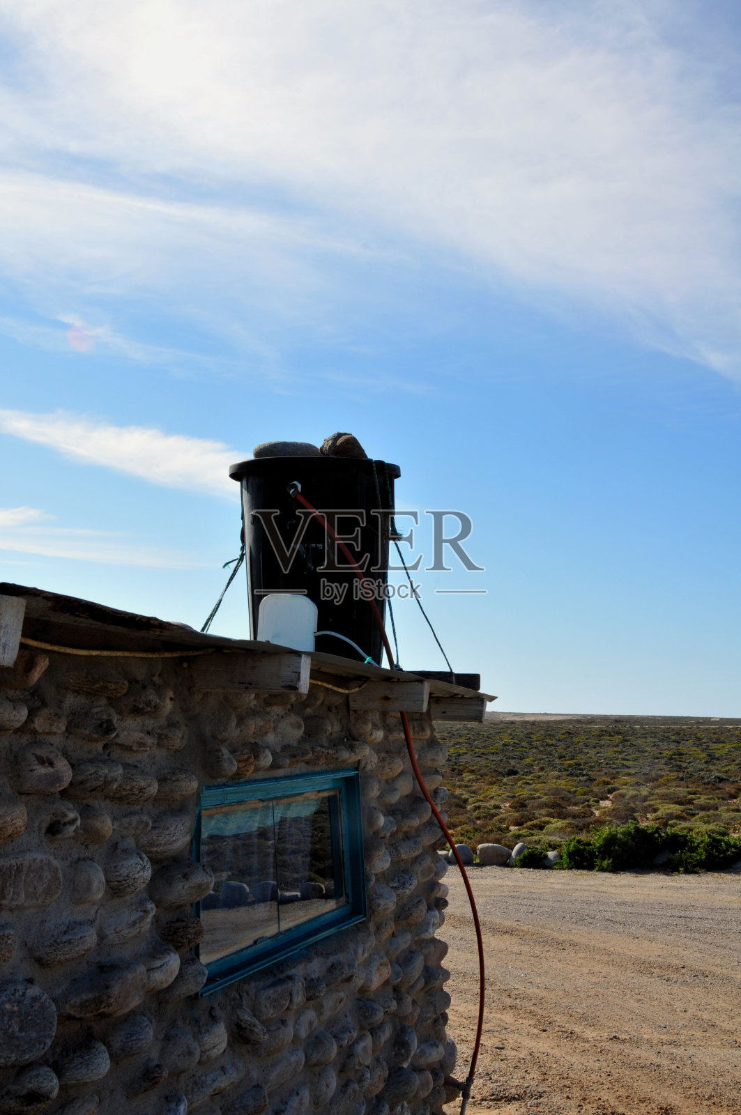 用一个黑色的橡胶垃圾桶加热来自太阳热量的水照片摄影图片