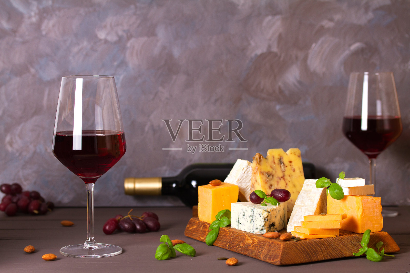 玻璃杯和一瓶红酒，配上奶酪和坚果照片摄影图片