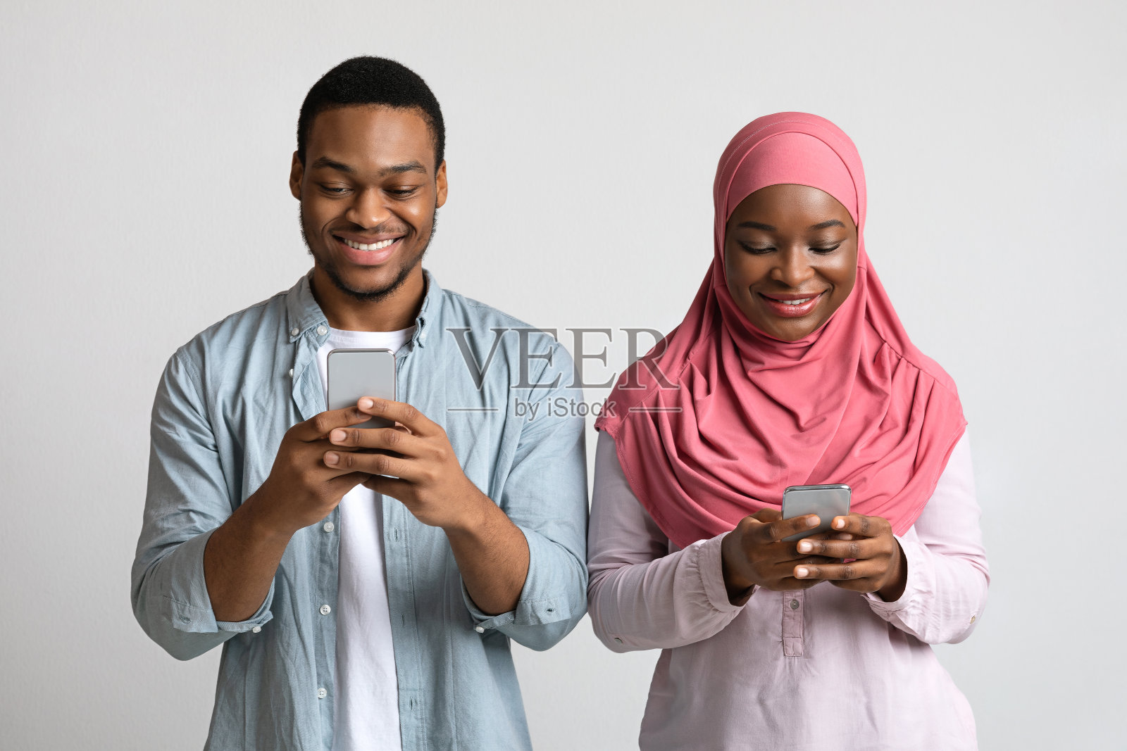 快乐的穆斯林男女一起玩智能手机照片摄影图片