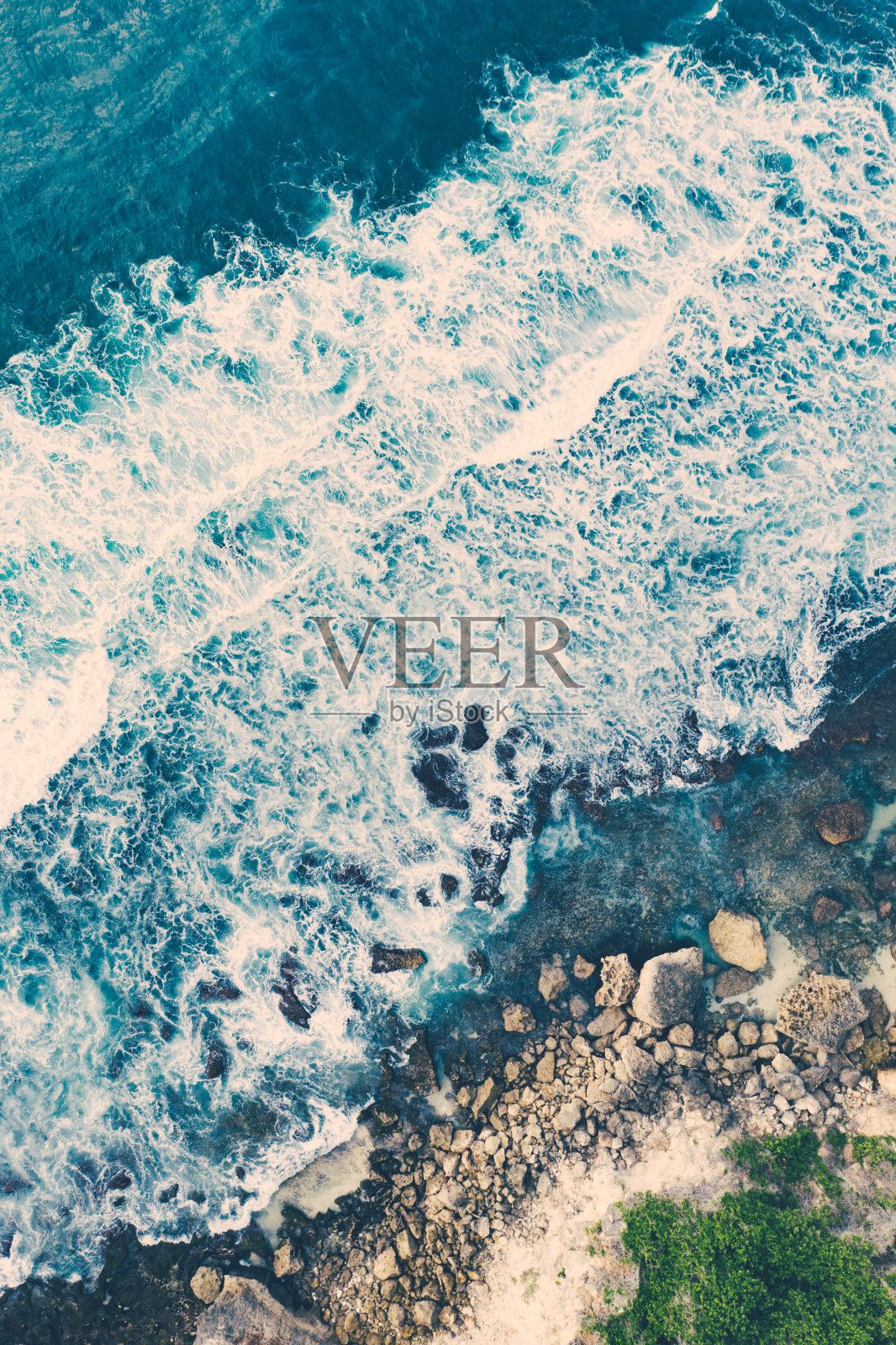 海浪拍打着布满岩石的海滩。从以上观点。照片摄影图片