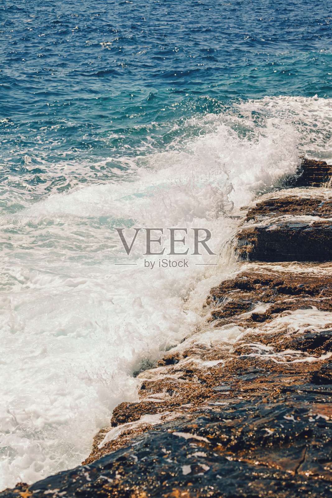 在希腊岛上，海浪拍打着岩石海岸的惊人景象照片摄影图片