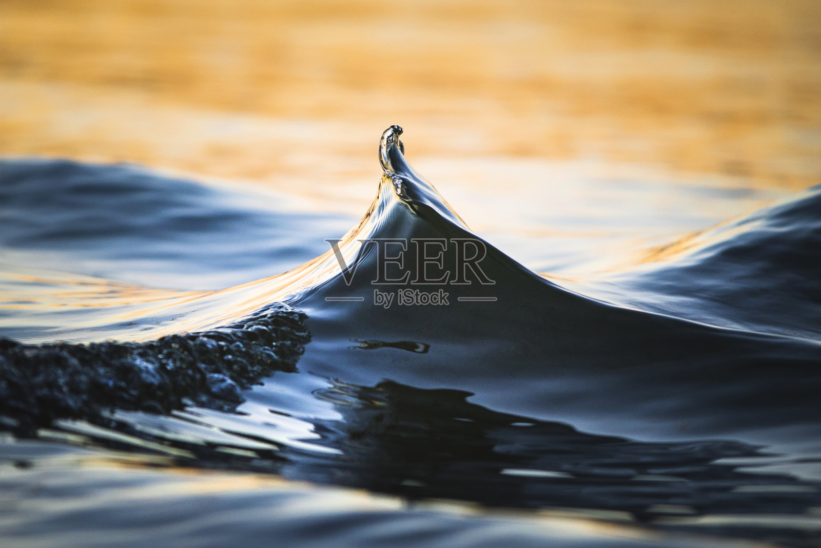 午后金色的阳光下，沙滩上的小波浪起伏照片摄影图片