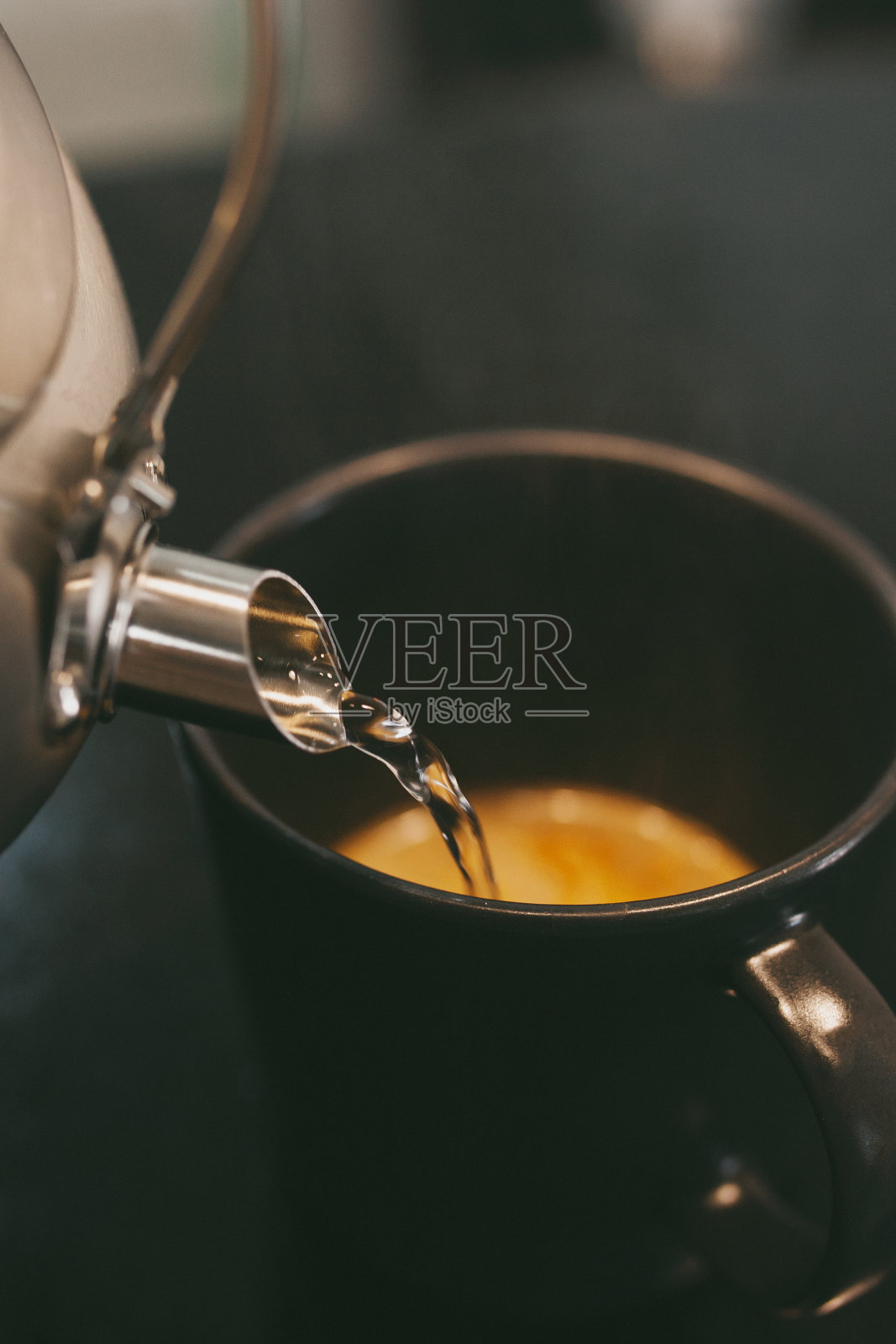 在家里用黑色的杯子煮咖啡，用热水照片摄影图片