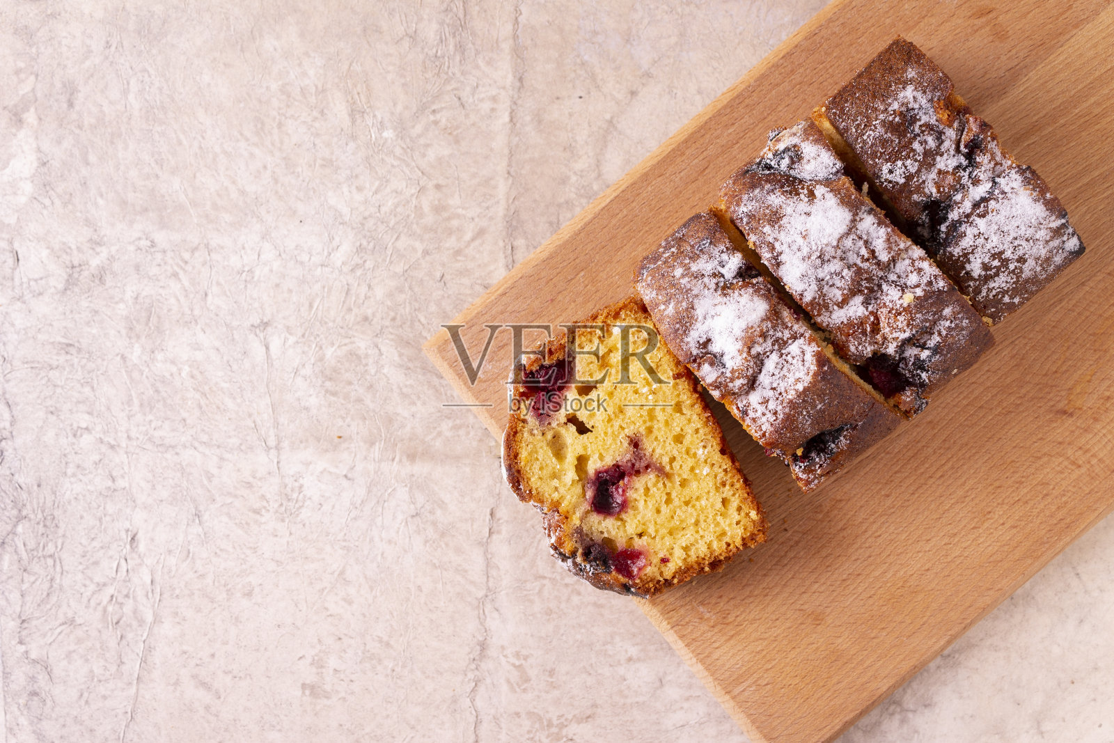 自制小蛋糕，米色背景，木板上放樱桃。照片摄影图片