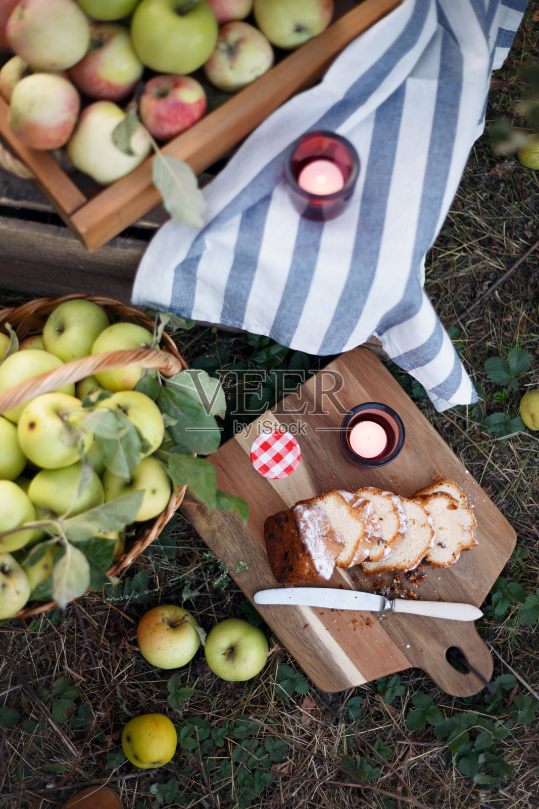 静物篮，花园里有多汁的苹果，纸杯蛋糕和蜡烛。气氛和情绪“n照片摄影图片