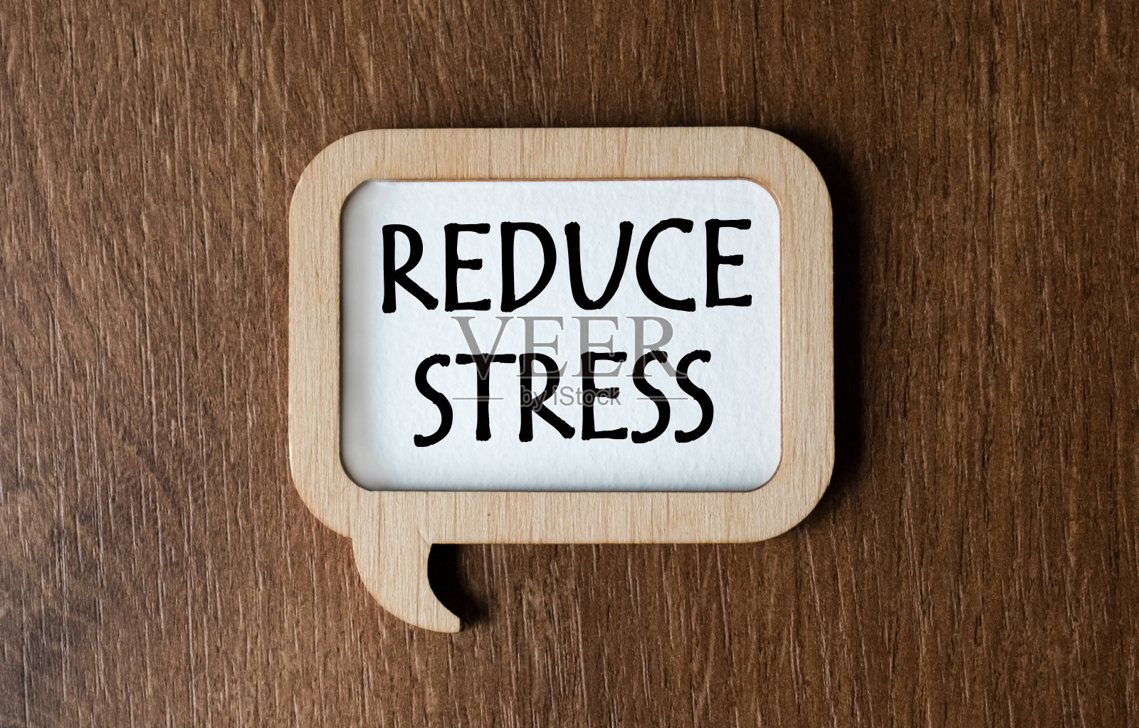 桌子上放着一块刻着“减压”字样的木牌。从以上观点。平的。市场营销的概念。照片摄影图片