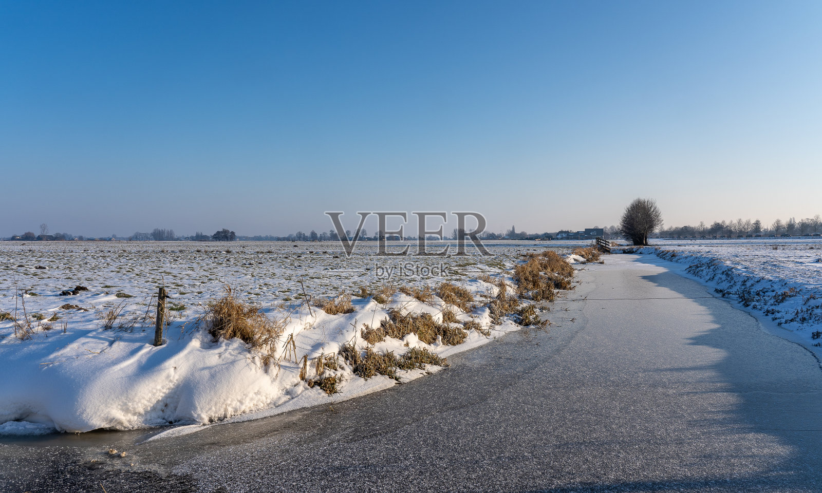 白雪皑皑的景色和结冰的沟渠照片摄影图片