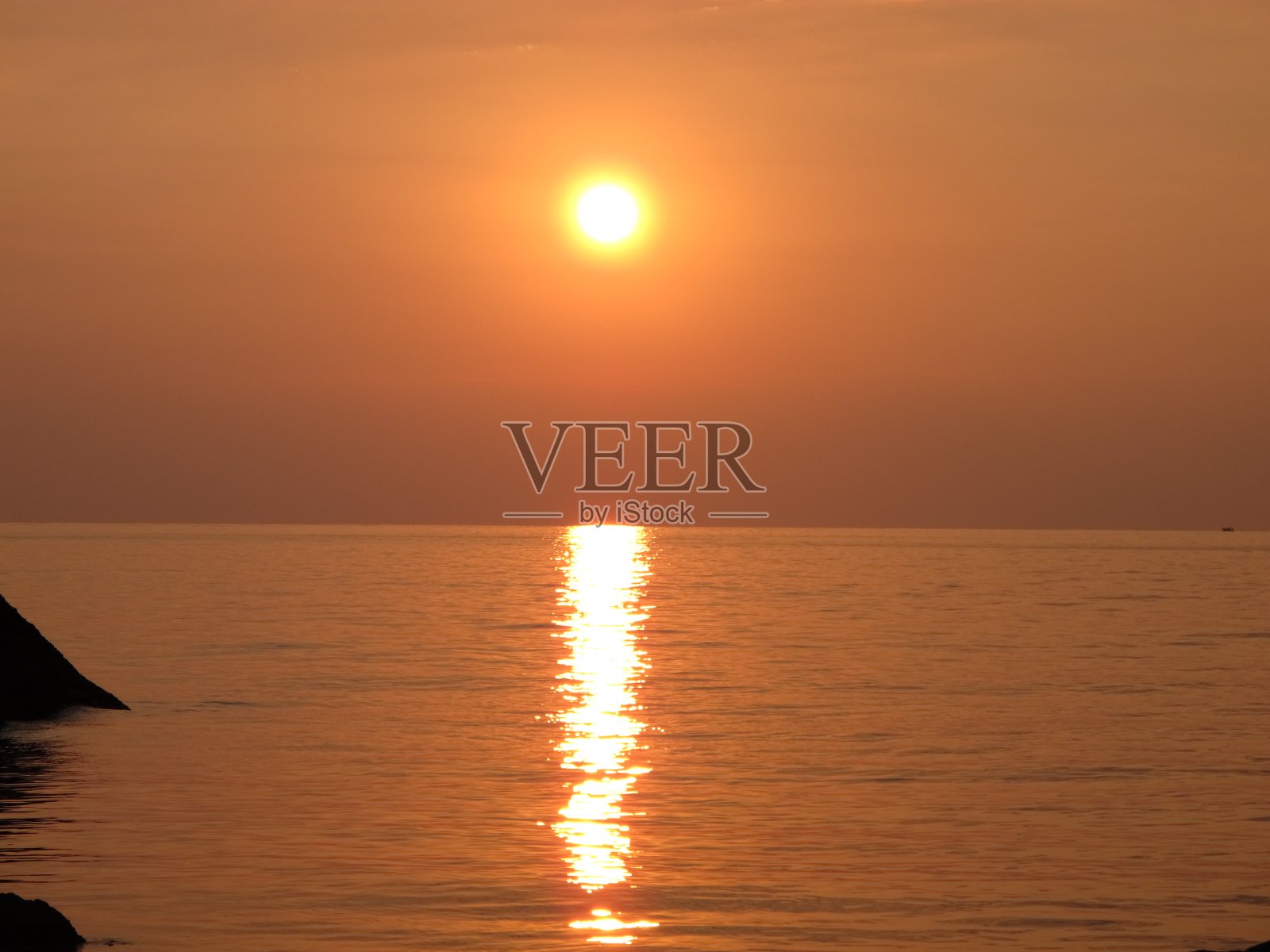 夏日傍晚，海岸上青铜色的落日照片摄影图片