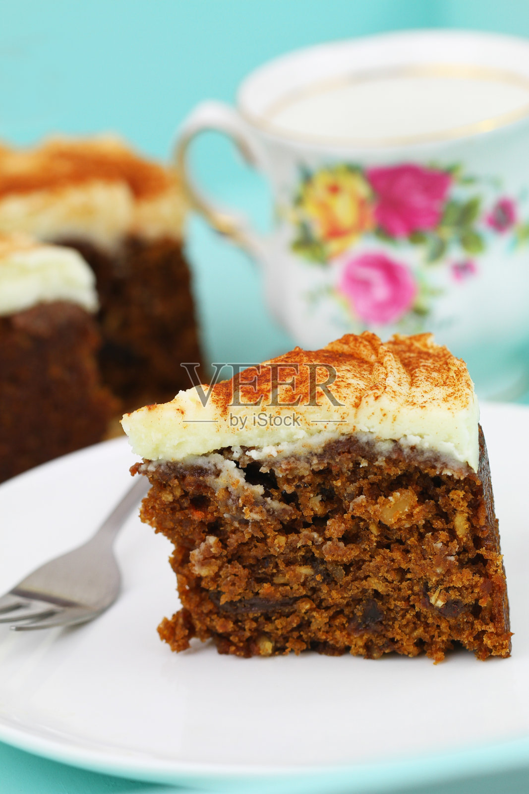 一片美味的胡萝卜蛋糕、核桃和杏仁糖霜放在白色的盘子上照片摄影图片