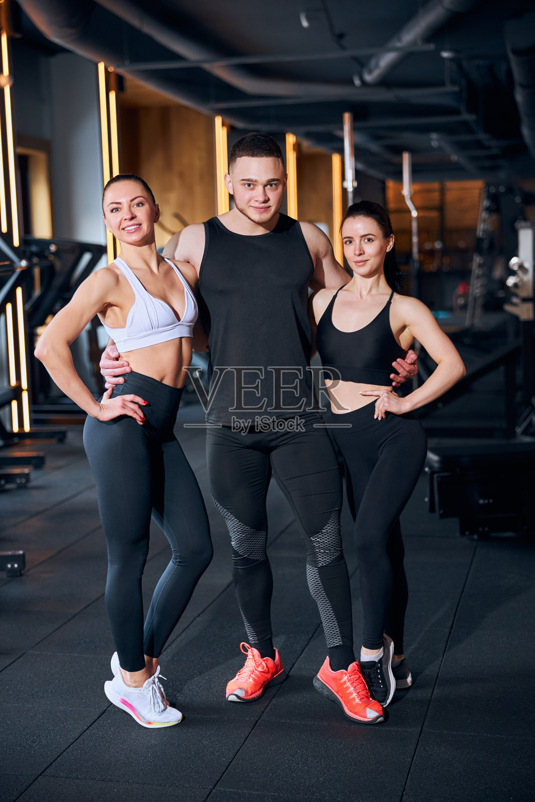 在健身房工作的年轻教练团队照片摄影图片