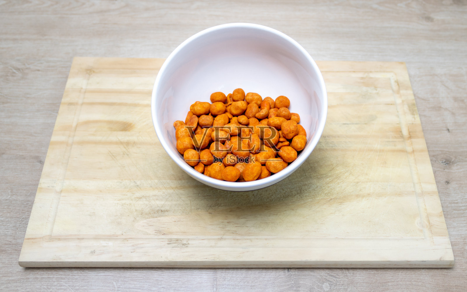 烤脆的花生和红辣椒放在碗里，放在厨房的板子上，有不同的口感。朋友聚会时广泛使用的小吃。照片摄影图片