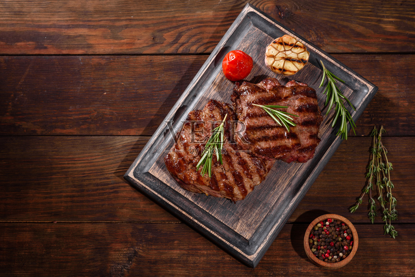 新鲜多汁美味的牛排在黑暗的背景照片摄影图片