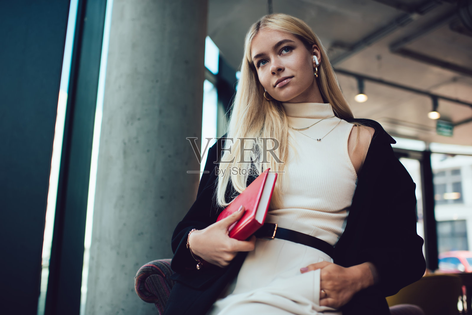 沉思的女人与书享受音乐在咖啡馆照片摄影图片