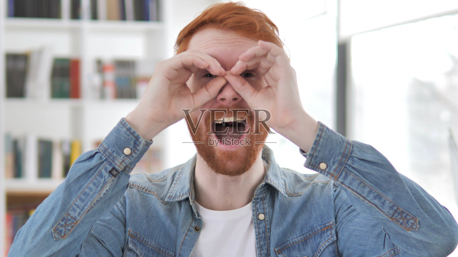 手工双眼，年轻的红发男寻找新的机会照片摄影图片