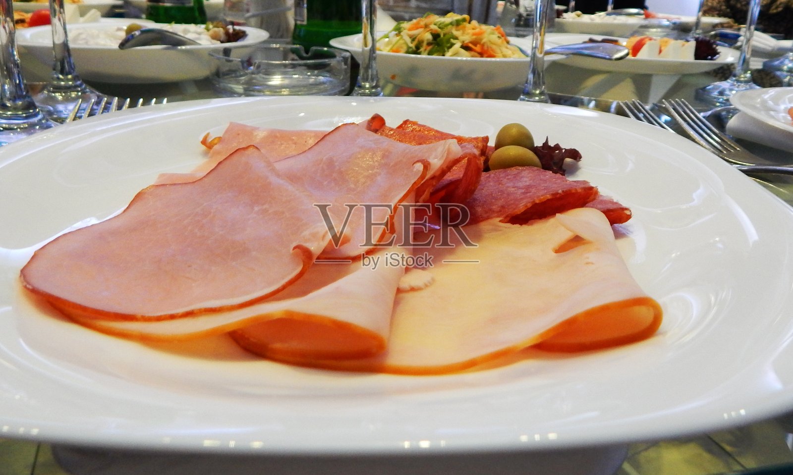 开胃菜。火腿和熏火腿在盘子里照片摄影图片