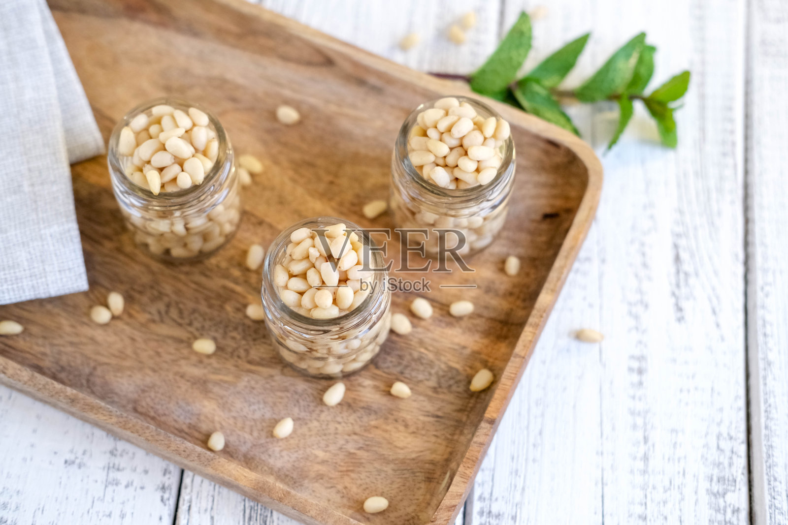 木背景上的玻璃柜里的雪松坚果。健康的食物照片摄影图片