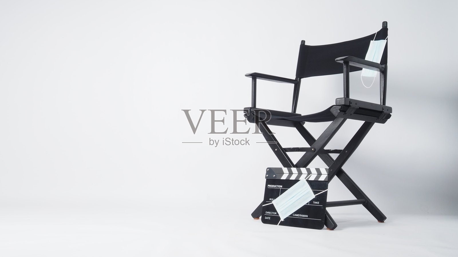 主任椅附有一个悬挂式面罩和面罩上的黑色拍板盖。它用于视频制作和电影工业上的白色背景。照片摄影图片