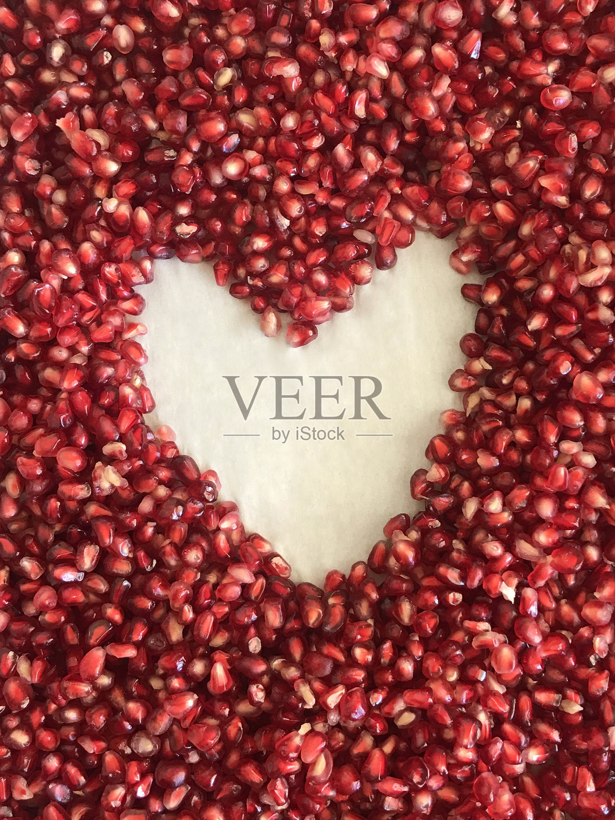 石榴籽心形框架在白色的背景照片摄影图片