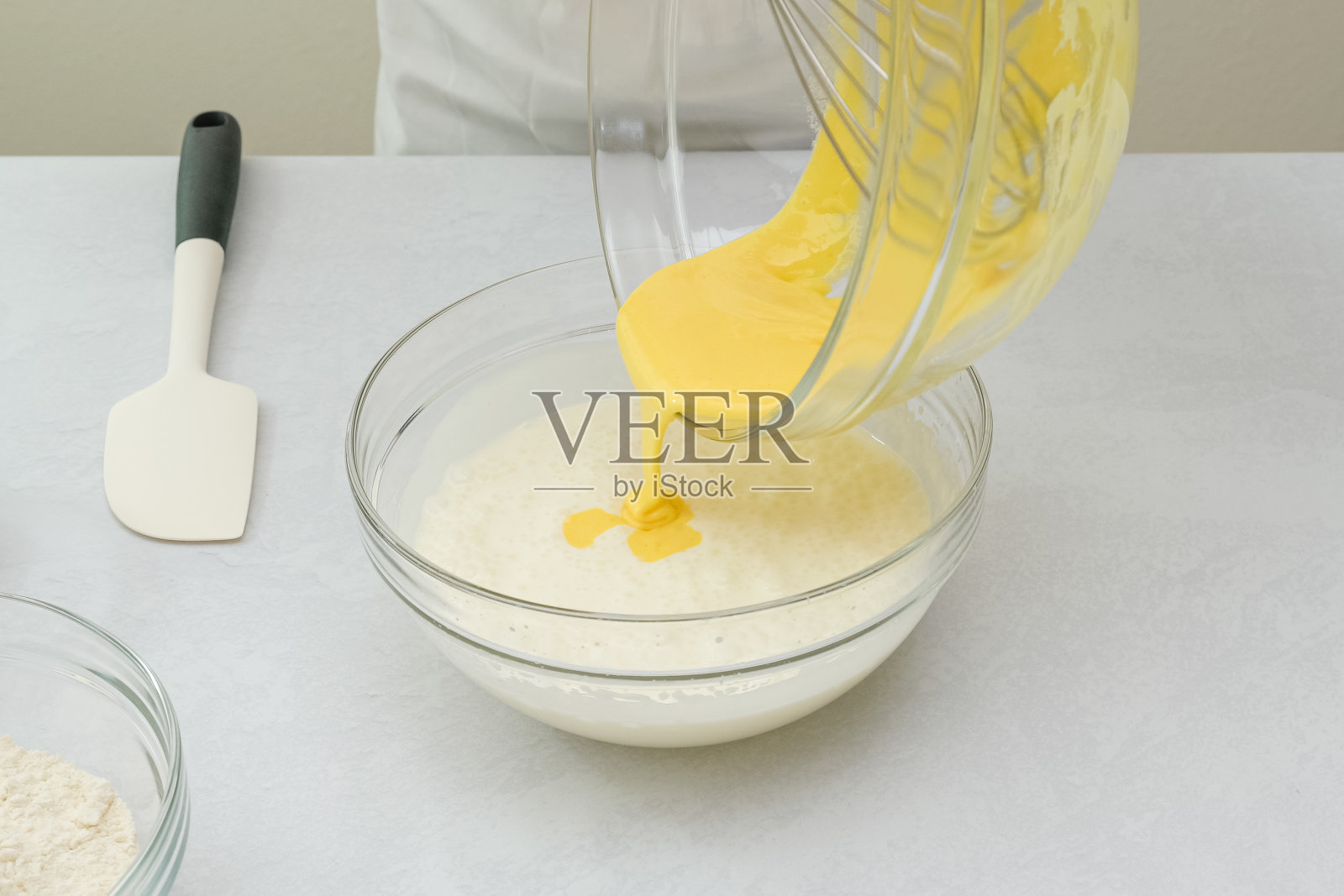 蛋白和蛋黄在一个玻璃碗中搅拌均匀。烘焙过程中，一步步制作巧克力蛋糕照片摄影图片