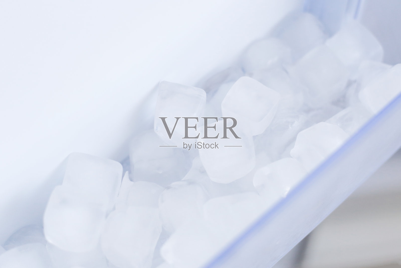 家用电器。冰块放在打开的白色冰箱里照片摄影图片