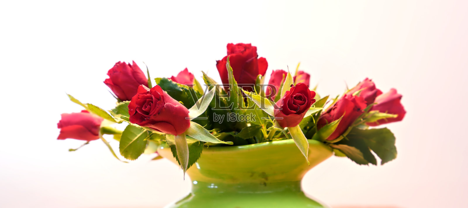 灯光背景下的一束红玫瑰照片摄影图片