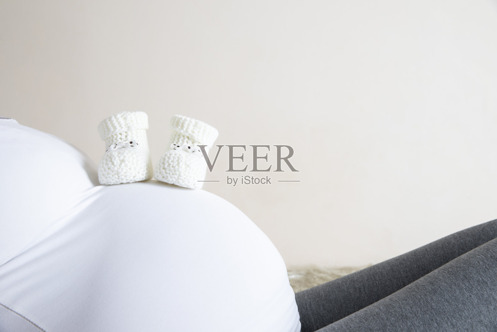 抱着婴儿鞋的孕妇照片摄影图片