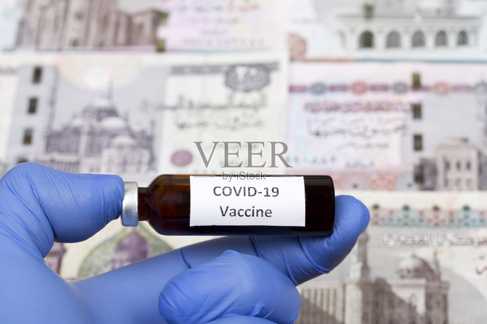 以埃及镑为背景的新冠肺炎疫苗照片摄影图片