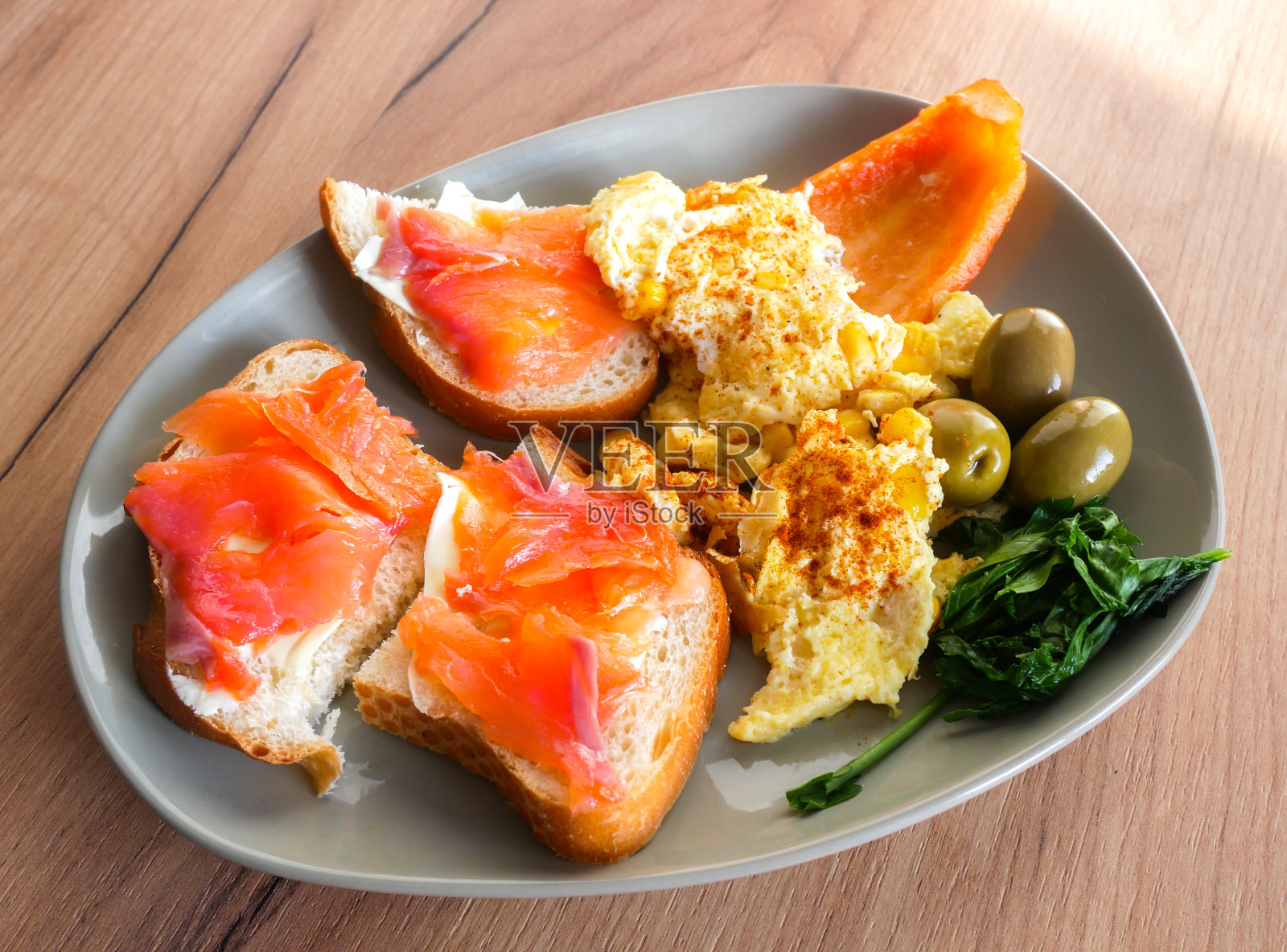 健康的早餐。橄榄，胡椒和芝麻菜沙拉煎蛋卷。鲑鱼配全麦面包。照片摄影图片