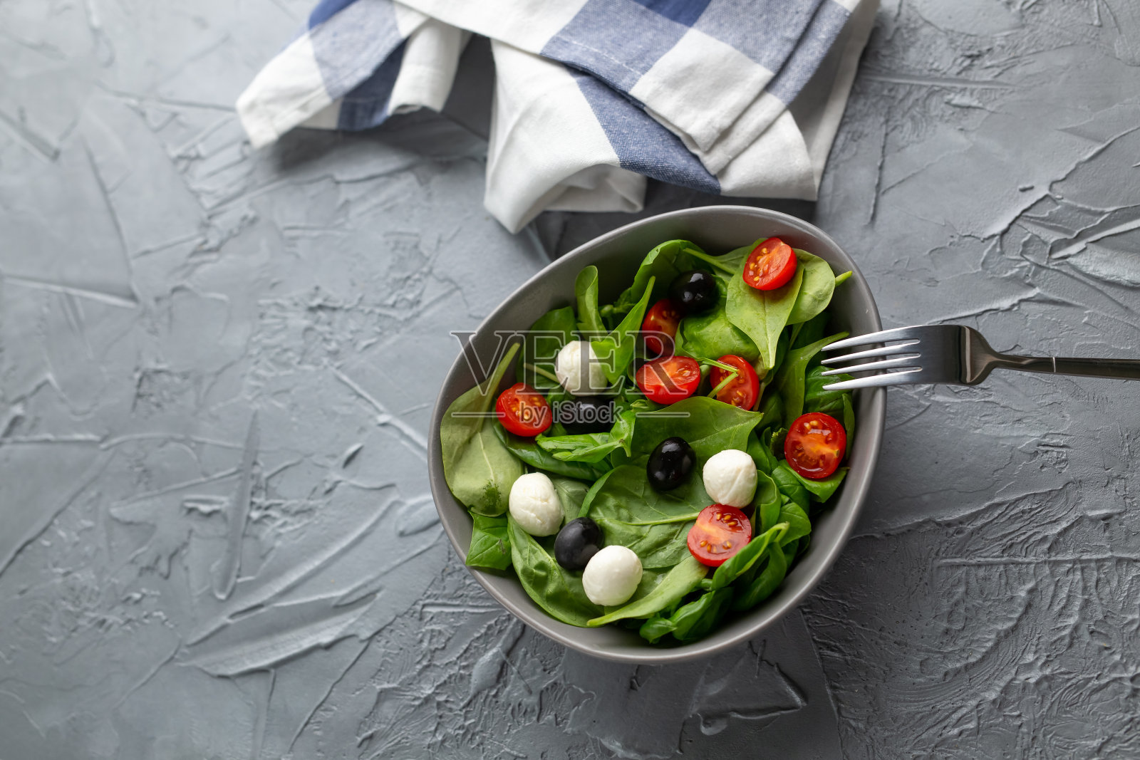 新鲜的马苏里拉芝士沙拉，西红柿和菠菜。健康的减肥食品。照片摄影图片