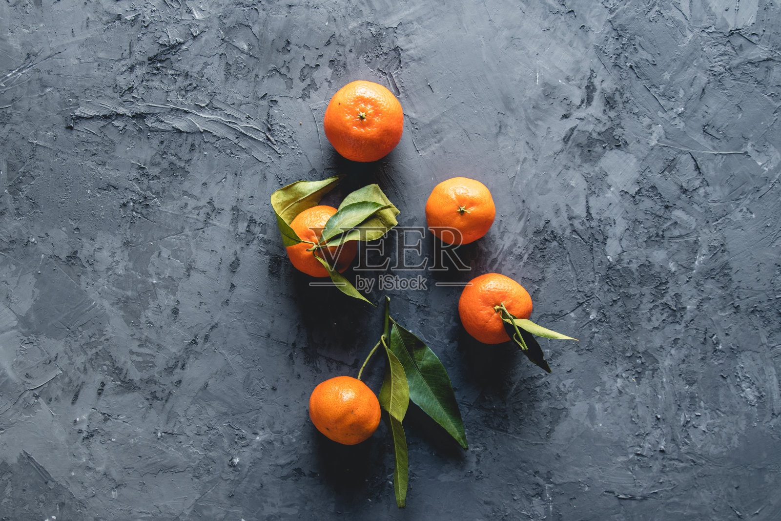 木桌上放着熟透多汁的橘子和叶子照片摄影图片