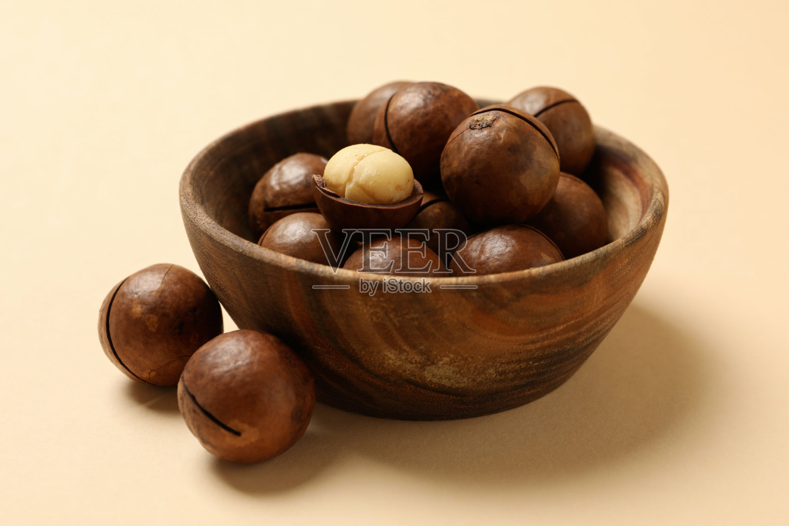 碗与美味的澳洲坚果米色背景照片摄影图片