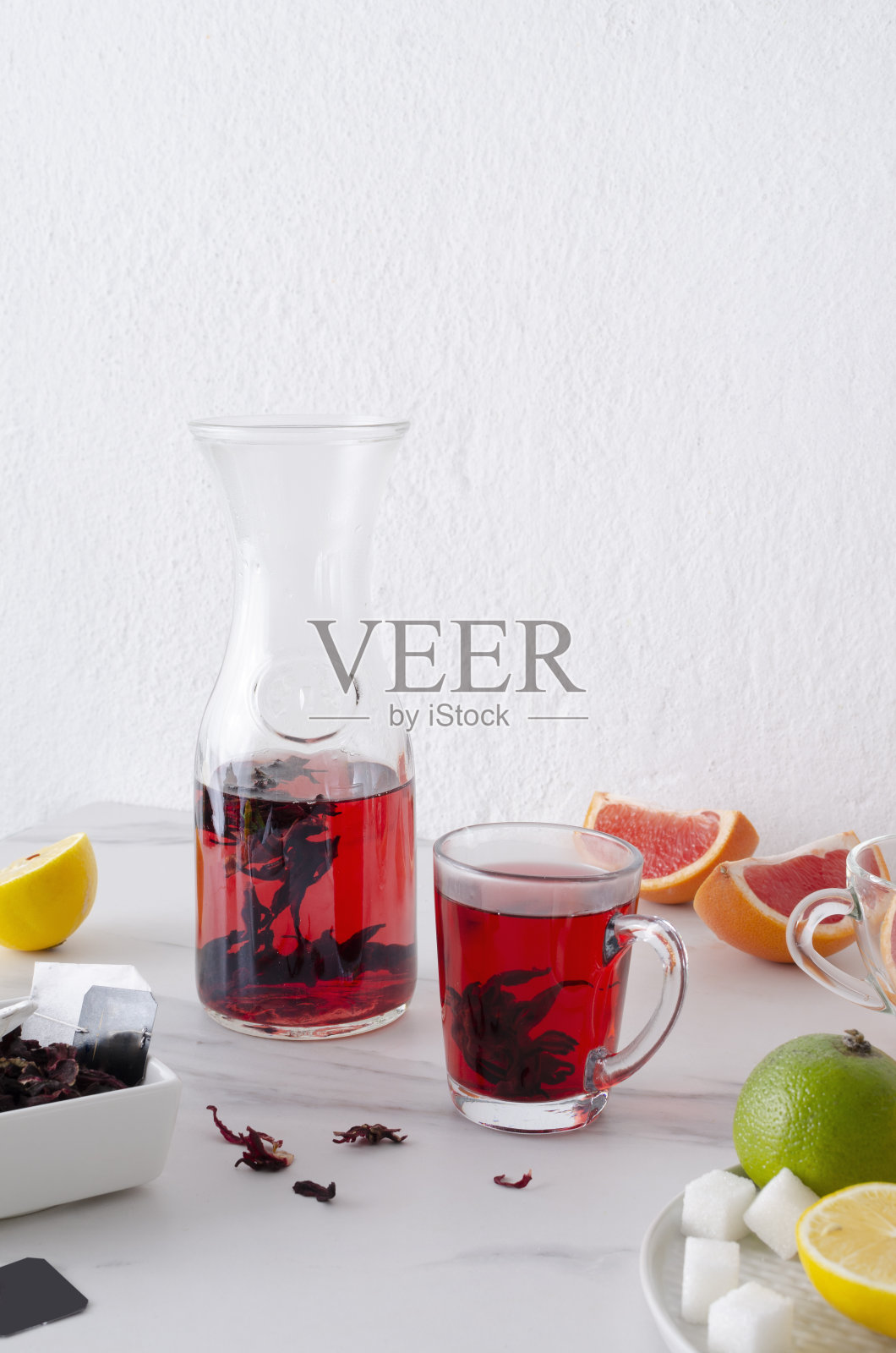 早晨花草茶。白色的桌子上放着健康的柑橘茶和新鲜的水果照片摄影图片