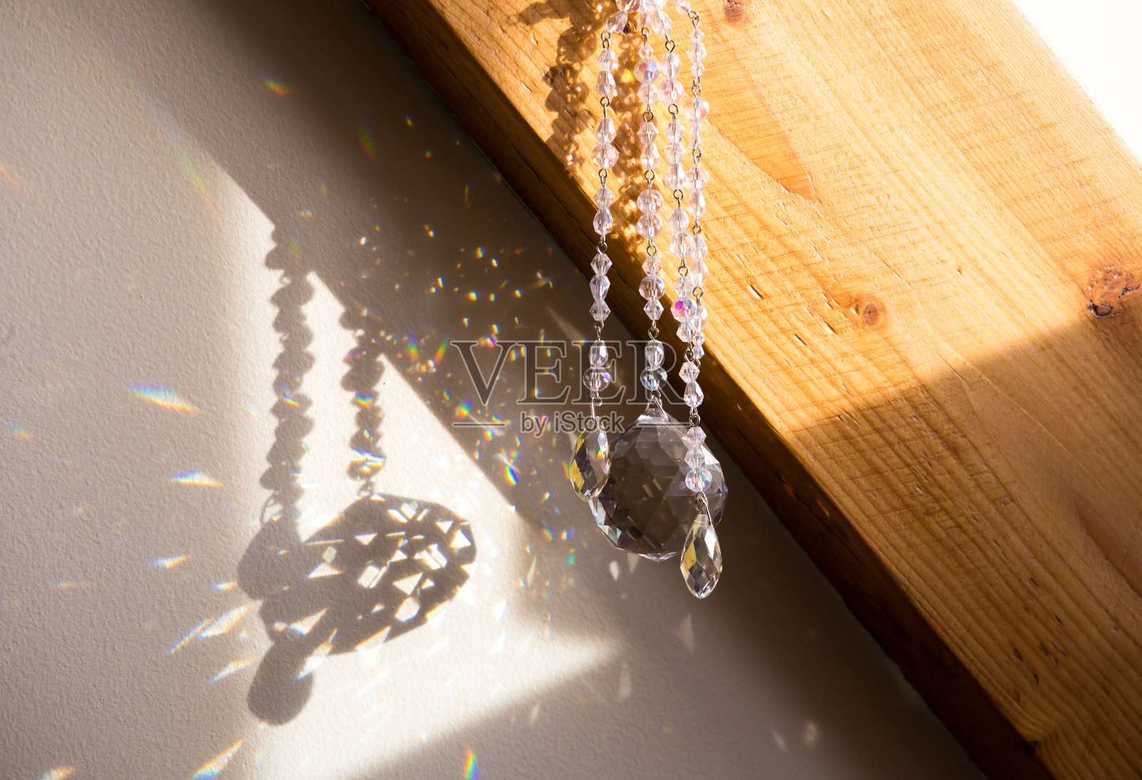 选择性专注于球和泪滴形状的水晶彩虹制造商挂在家里。风水好，能量流沙池概念。房间里有美丽的春光。照片摄影图片