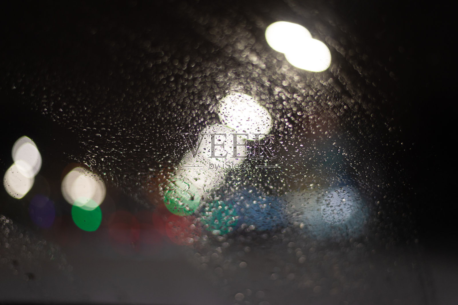 模糊的背景与雨滴和灯光。照片摄影图片