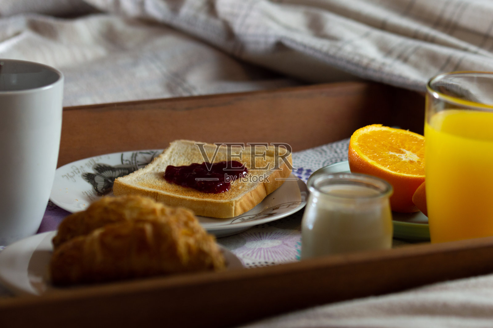 一张放在床上的木托盘上的早餐的特写。浪漫的早餐照片摄影图片