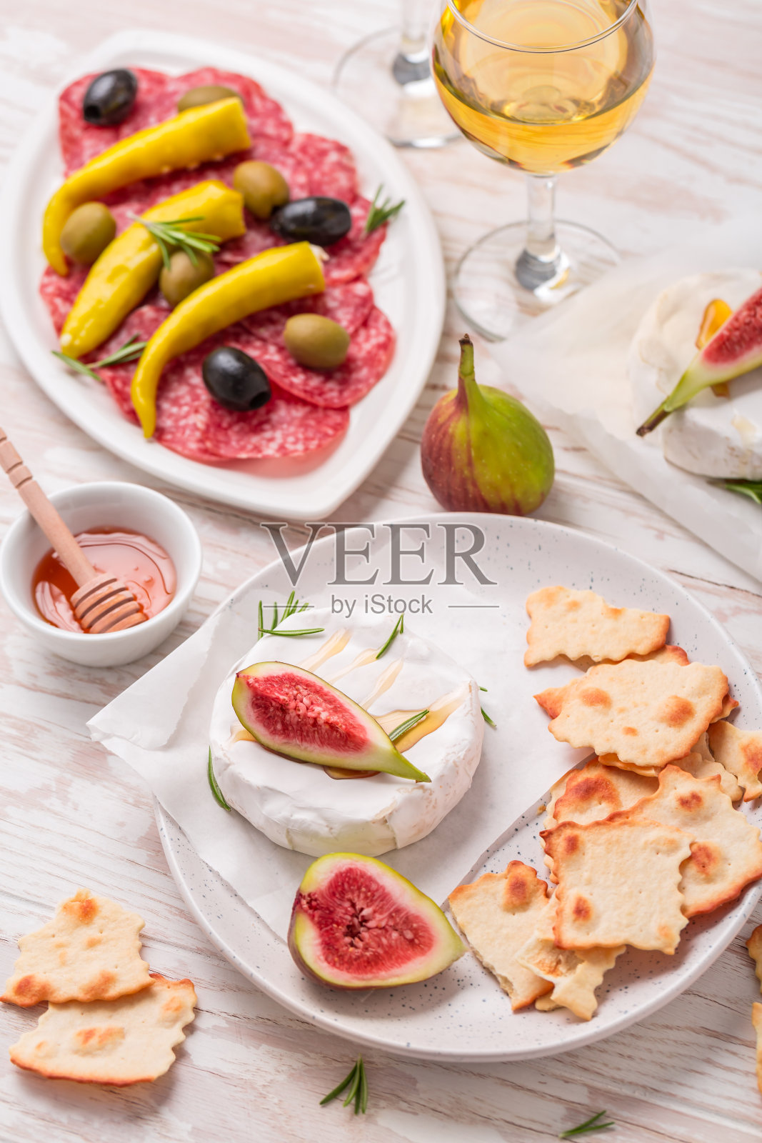 卡门贝尔乳酪配蜂蜜，无花果，开胃菜和一杯白葡萄酒照片摄影图片
