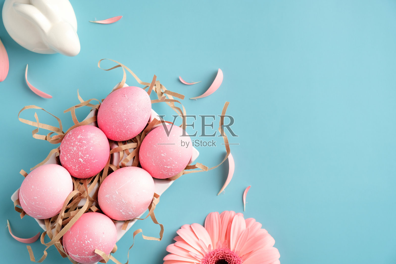 创意的布局与粉红色的复活节彩蛋，复活节兔子，春天的花朵在绿松石的背景。平铺，俯视图，拷贝空间。照片摄影图片