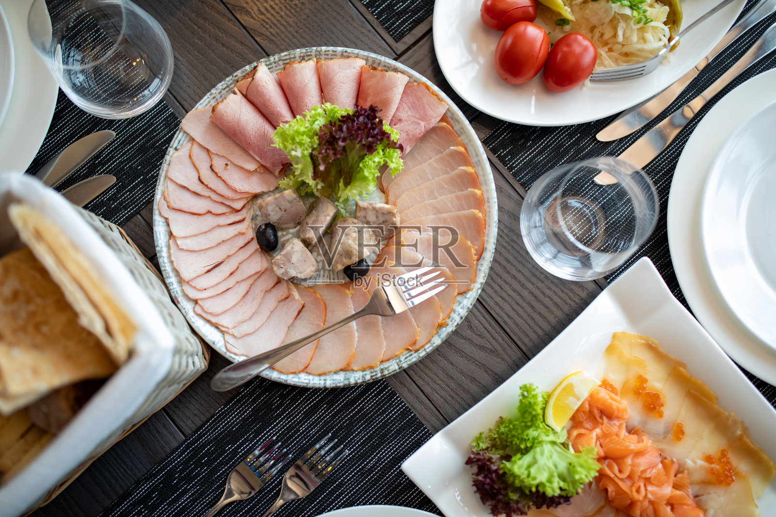 宴会前餐厅的餐桌餐具，包括银制餐具和玻璃高脚餐具照片摄影图片