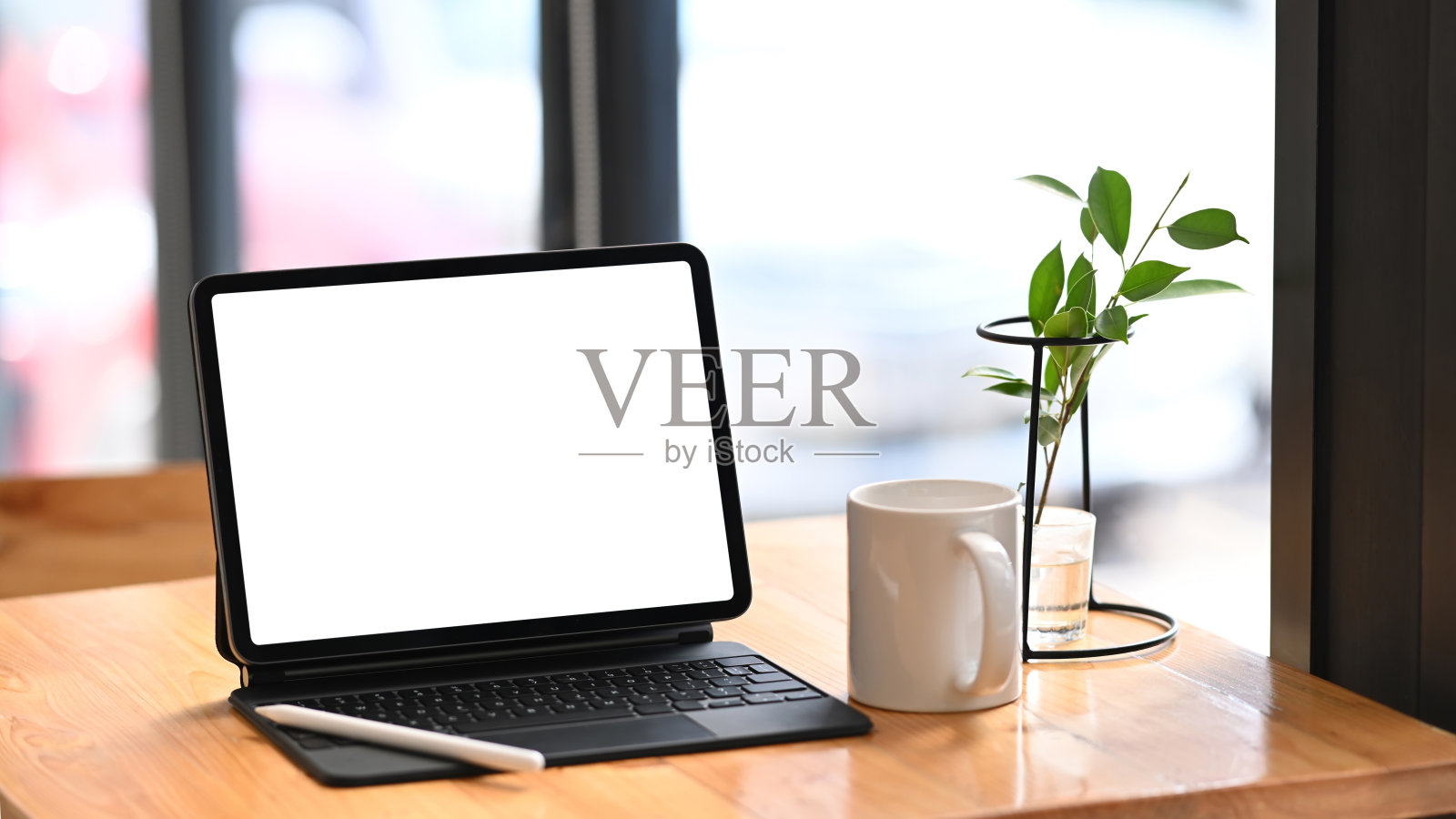 空白屏幕的平板电脑，咖啡杯和植物在最小的工作空间。照片摄影图片