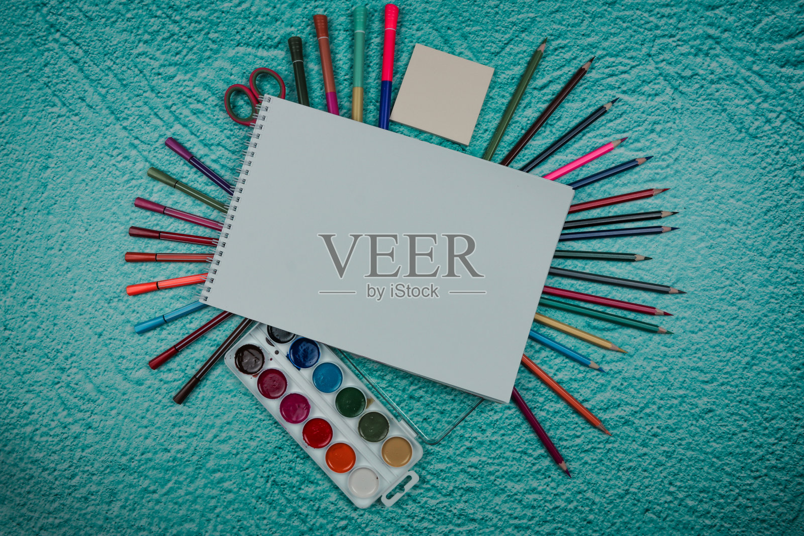 富有创意的平铺水彩调色板，画笔，白纸。在蓝色粉彩背景上的艺术家工作场所。照片摄影图片