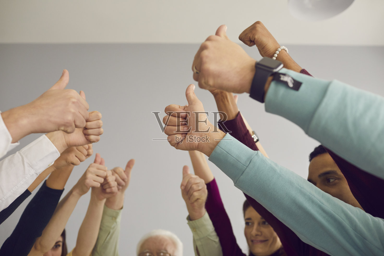 多民族团队给予赞许，庆祝成功的工作成果或投票为好主意照片摄影图片