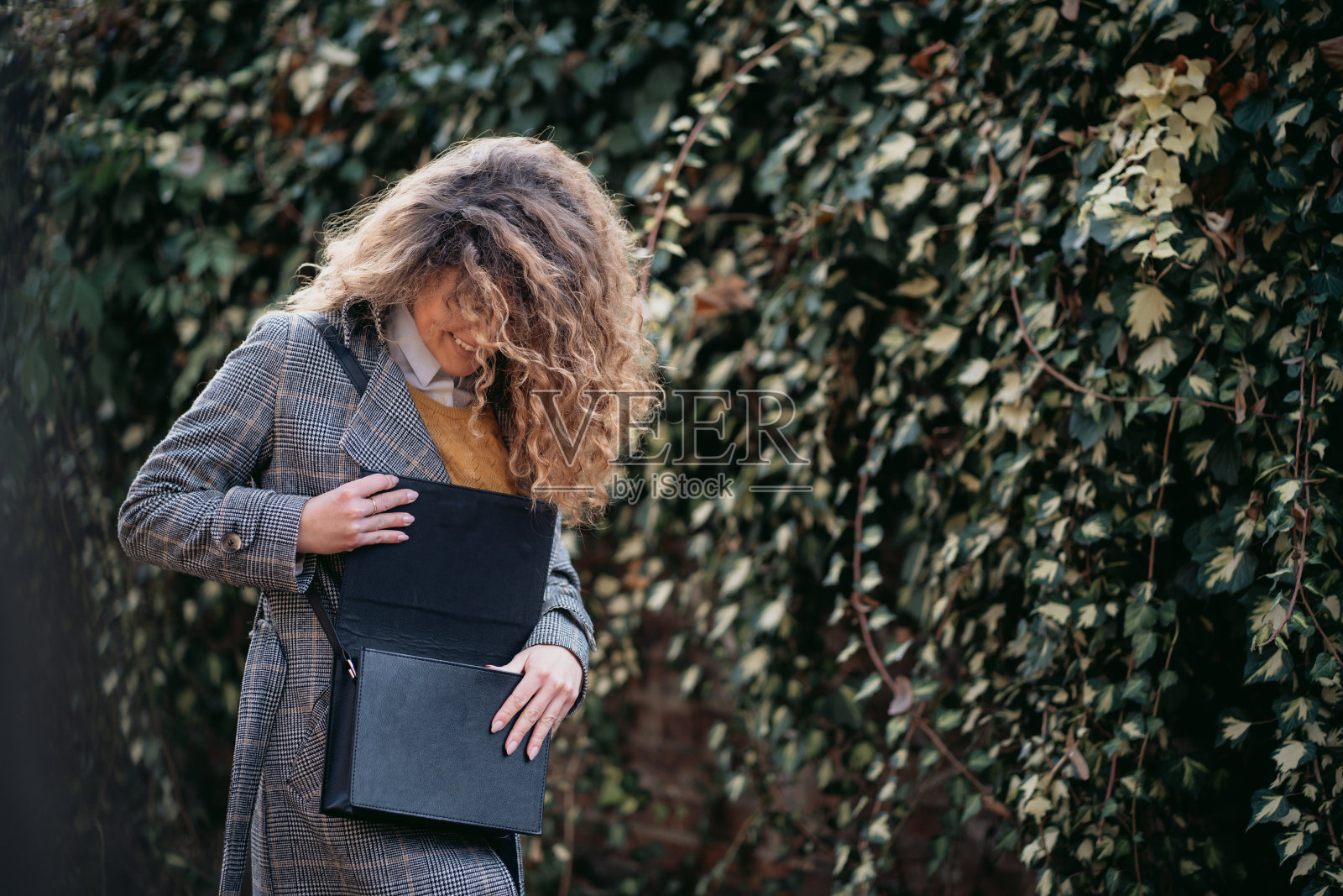 卷毛女人在钱包里找东西照片摄影图片