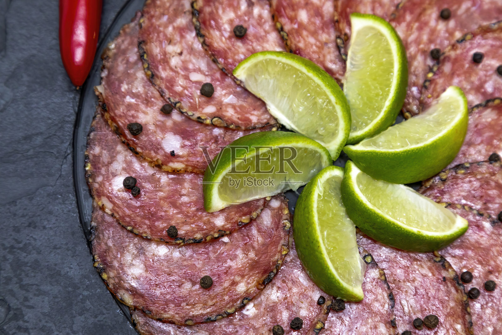 黑色的石板上放一份意大利腊肠照片摄影图片