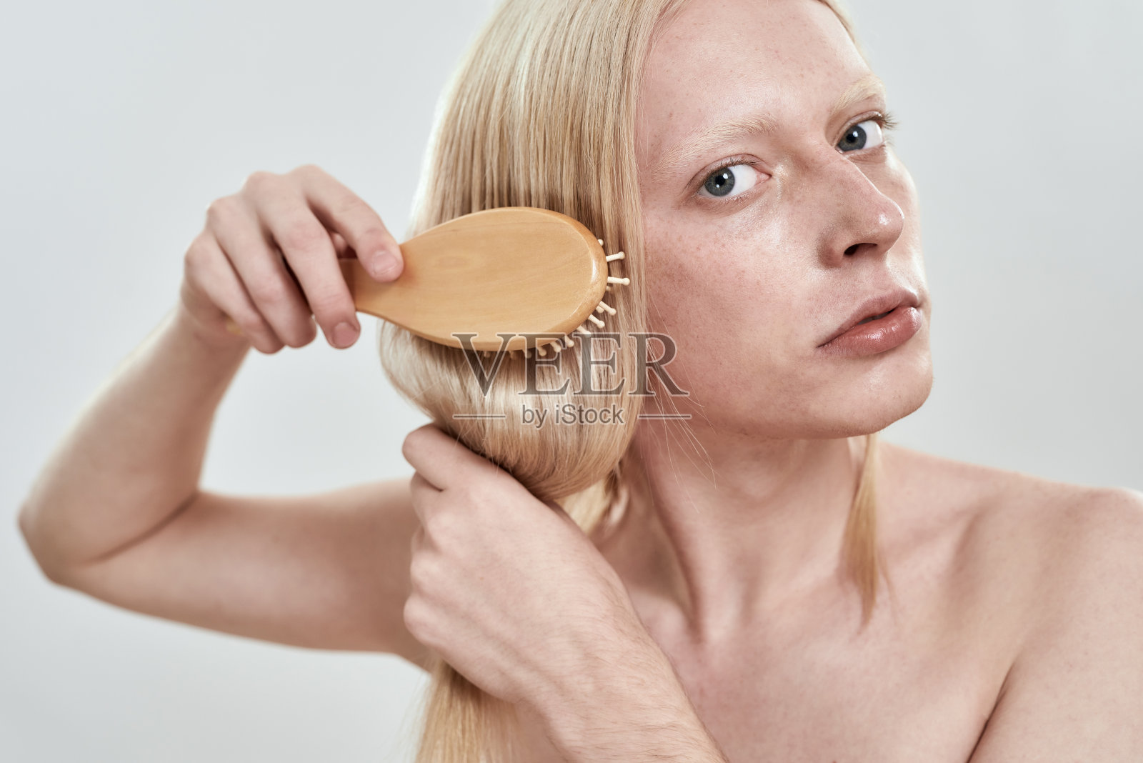 年轻白人男子梳理长发的肖像照片摄影图片