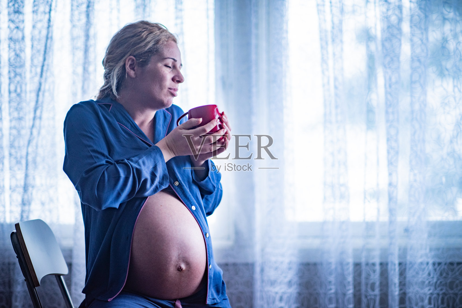 快乐的孕妇喝咖啡。照片摄影图片