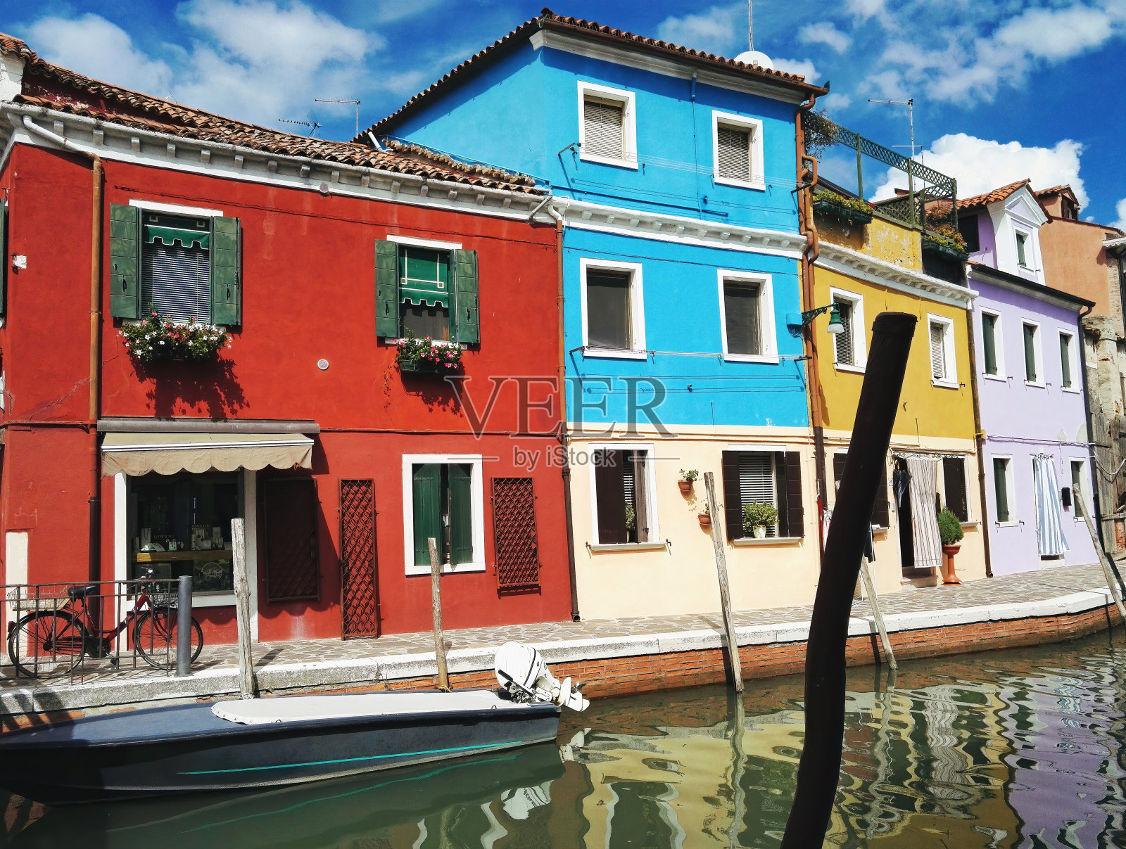 广角拍摄的摩托艇运输与色彩缤纷的意大利住宅建筑外观照片摄影图片